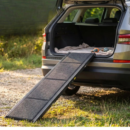 Rampe-pour-chien-chiot pout voiture de 180-cm universelle pour accès facile par la protière ou coffre de voiture, berline, monospace, camionette, SUV, 4x4, camping-car, réglable en Aluminium 6063 haute résistance avec des bords renforcés de 2 mm, cette rampe pour chien supporte jusqu'à 113 kg, antidérapante et 100% imperméable, pliable et compacte, légère de 7 kg transportable pour chiot et chien de toute race et toute taille-gros plan sur la rampe placé contre le coffre du SUV pour un accès facile 