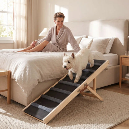 Rampe-pour-chiens-chiots pliable, en bois massif robuste de pin et surface adaptable en moquette douce et petites marches tranversales antidérapante pour un accès sécurisé et facile canapé, lit de la maison ou en transport en déplacement, en voiture pour la montée et la descente du chien en toute autonomie et sécurité, 5 hauteurs réglables -un chien de petite race au à pattes courtes qui descend du lit de sa maitresse pour la suivre en toute sécurité sur la rampe en bois dans l chambre de la maison