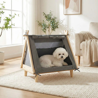 Tente-pour-chien-chiot-surélevé-bois naturel et tissu oxford 300D ultra-résistant et 100% imperméable avec une partie moustiquaire pour une circulation d'air optimale-un lit pour chiot et petit chien de 0 à 5 kilos solide et design écoresponsable dfe couleur crème avec son matelas ergonomique à mémoire de forme en éponge haute résilience 100% coton PP-un Coton de Tuléar couché confortablement dans sa tente sur pieds en bois et rideaux amovibles dans le salon de l'appartement