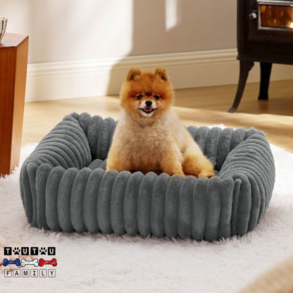 panier-petit-chien-lit-un-chiot-assis-dans-son-panier-de-couleur-gris-de-forme-rectangulaire-avec-coussin-entourant-sur-360°-pour-un-ffet-panier-anti-anxité-et-sécurisant-fond-antidérapant
