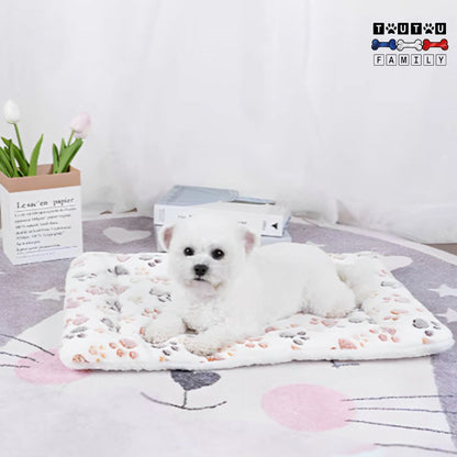 tapis-pour-chien-couverture-polaire-chaude-lavable-un-chiot_coton-de-tuléar-couché-sur-son-tapis-polaire-imrimé-pattes-de-chien